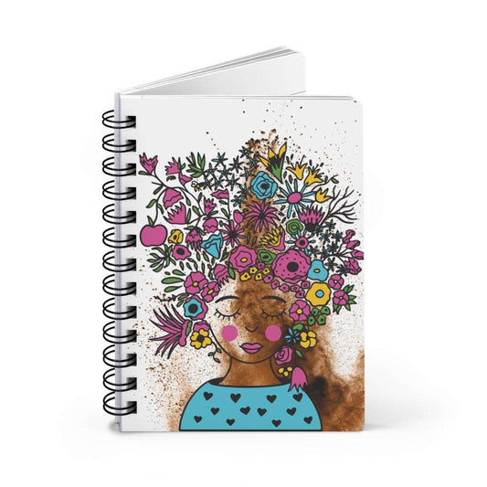 A Paint Splattered Floral Journal for Women adorned with a whimsical illustration of a woman with flowers blooming atop her head, perfect for self-expression and journaling.