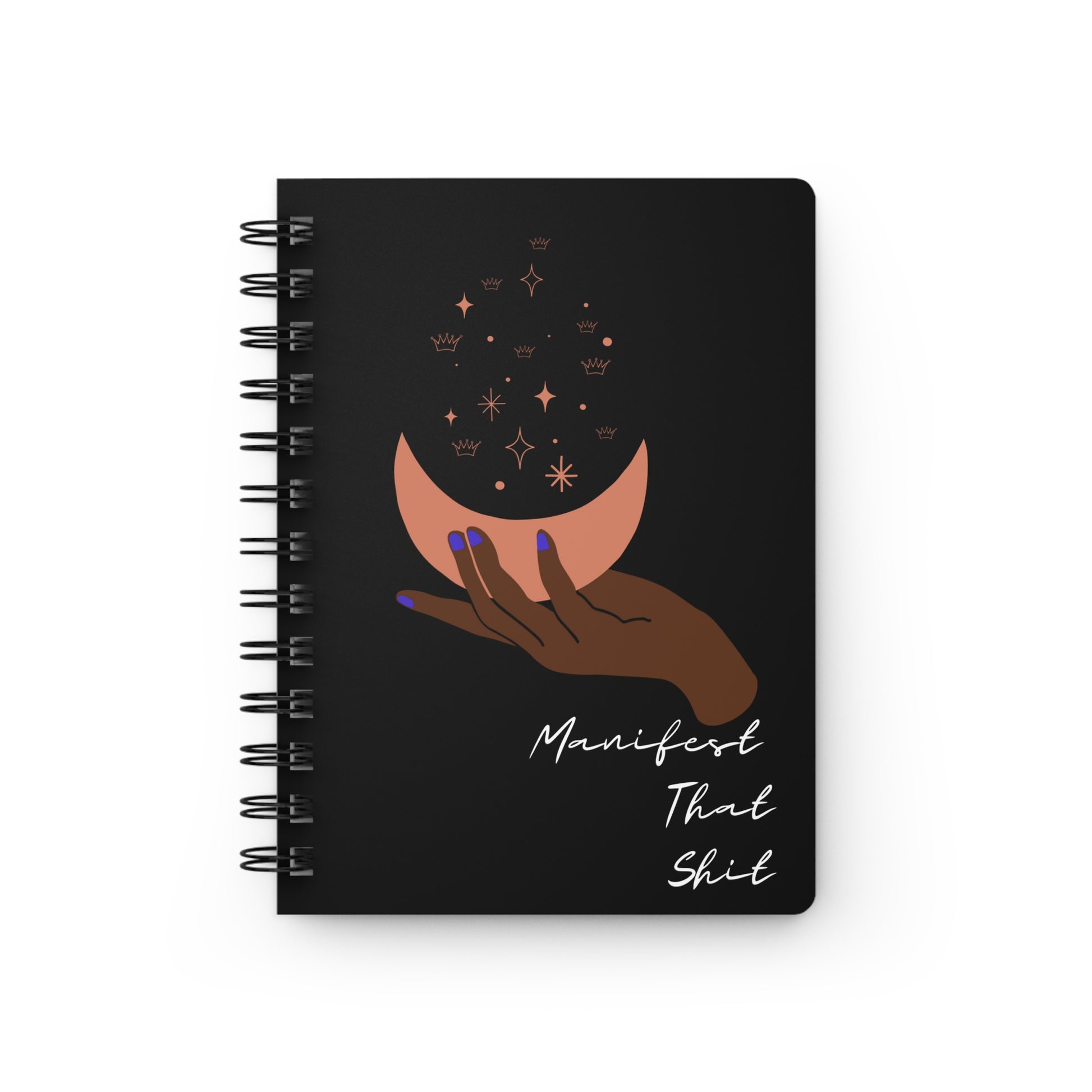 A "Manifest That Shit" manifesting journal adorned with a captivating black spiral notebook design featuring a hand holding a crescent and stars, perfect for practicing the law of attraction and gratitude journaling.