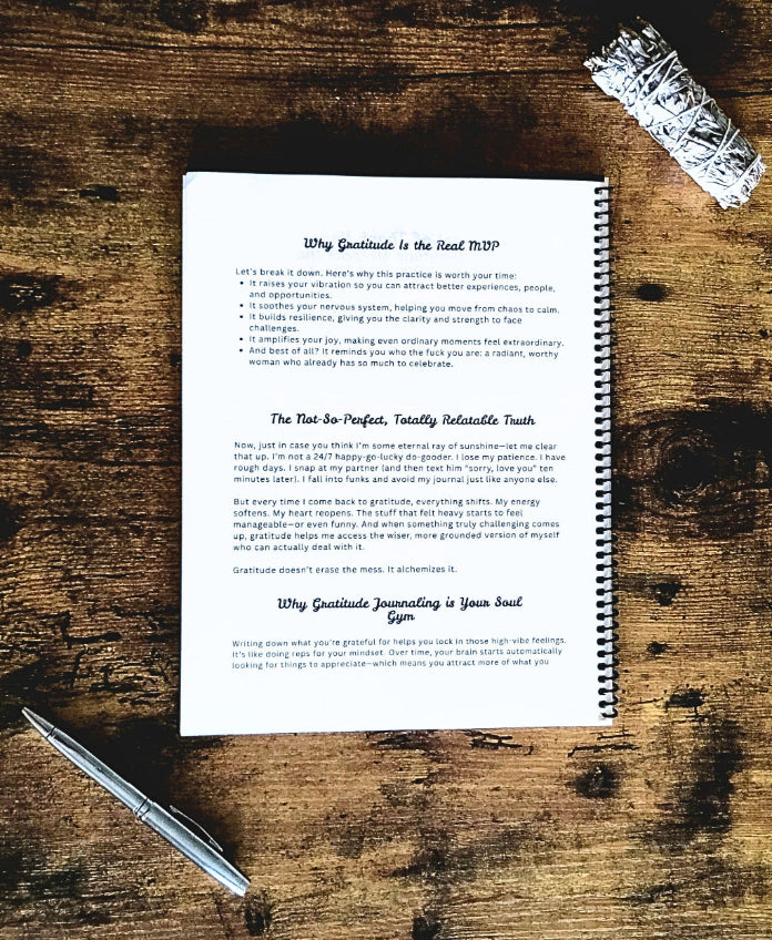 Notebook with text on a wooden surface with a pen and sage
