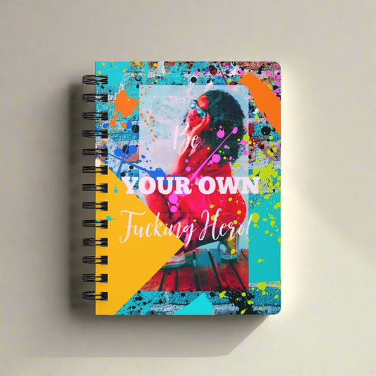 A "Be Your Own Fucking Hero" Spiral Bound Journal for Black Women with a colorful photo of a woman, perfect for self-reflection and embracing new beginnings.