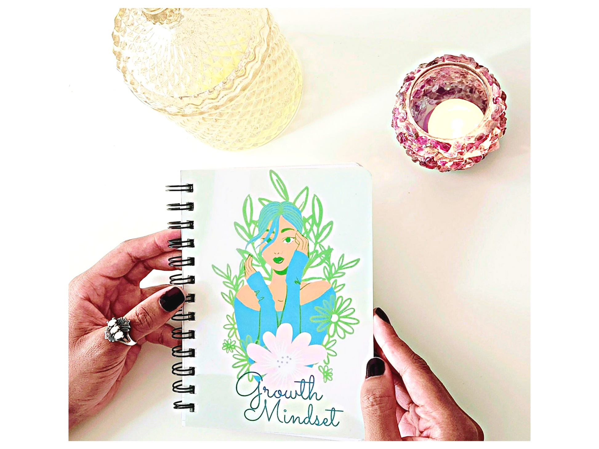 A person holding a "Growth Mindset" Inspirational Journal for Success and Self Improvement with a reflective drawing of a woman holding a flower.