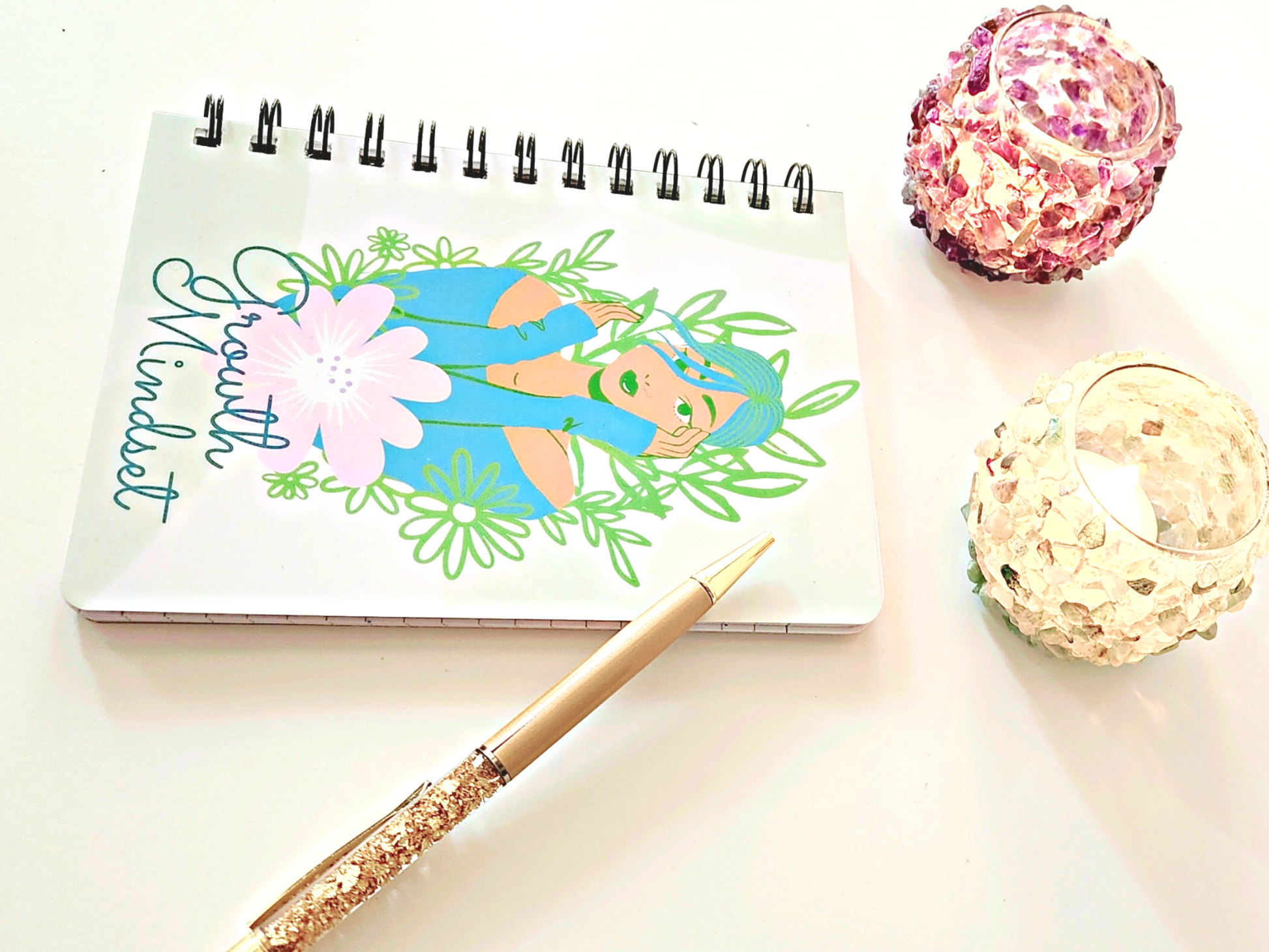 An "Growth Mindset" Inspirational Journal for Success and Self Improvement notebook for reflective journaling with a flower and a candle next to it.
